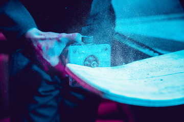 Skater in process of making his own skateboard, longboard - open business concept. Neon lighted...