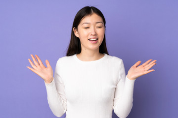 Young asian woman isolated on purple background smiling a lot