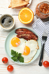 Delicious breakfast or lunch with fried eggs on white wooden background, top view