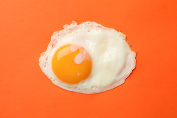 Fried egg on orange background, top view