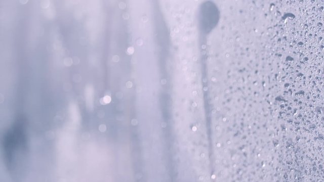 Drops of water on glass in the shower. Water flow down on glass wall in bathroom shower, Nobody. Motion 4k video, 3840x2160 footage