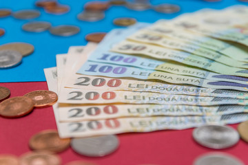 Romanian banknotes and coins on a blue and red background. Coloseup of RON, Romanian Currency. Romanian RON, Lei Banknotes issued by BNR, National Bank of Romania. Romania Finance and economy concept