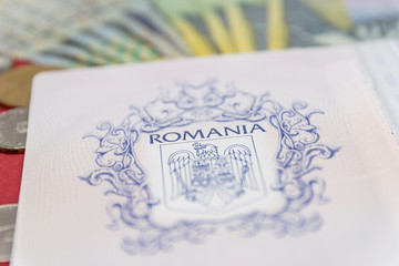 Romanian concept. The Romanian passport and Romanian banknotes/coins on a blue and red background. Coloseup of Romanian Passport and Romanian currency. Romania Finance and economy concept