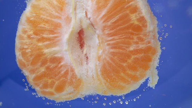 Orange mandarins, tangerine peel or mandarin slice in macro. fresh citrus fruit in water under water.