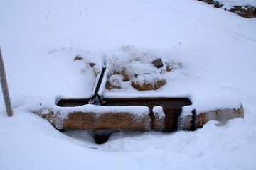 Quelle und tränke auf dem feldberg im hochschwarzwald, die mit schnee bedeckt ist