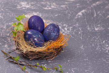 space easter eggs in nest on gray background. Selective focus. Copy space