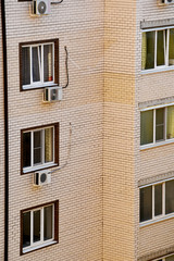 Obraz premium Part of the building, light brick facing, balconies and air conditioning. Large windows at the multi-storey new building.