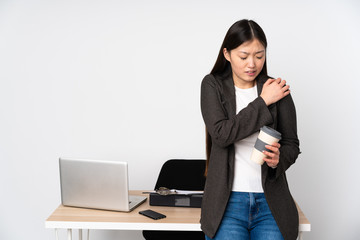 Business asian woman in her workplace isolated on white background suffering from pain in shoulder for having made an effort