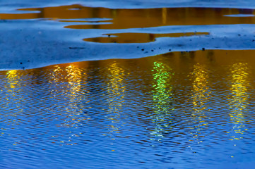 Fototapeta na wymiar Reflection of light from streetlights on wet asphalt.