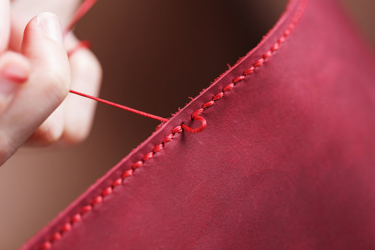 Conceptual profession of a Tanner. The woman's hands closed around the needle and thread.