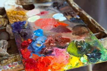 artist wooden palette, mess of fresh bright colorful oil paints mixed in disorder, outdoor painting plein air, creative vibrant inspiration postcard