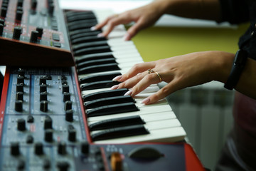 woman's hands are playing the synthesizer close up