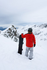 Fototapeta na wymiar Whistler, British Columbia, Canada. Adventurous Man with a snowboard in the Alpines on top of Blackcomb Mountain.