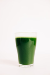 green freshly squeezed juice of green Apple and young spinach leaves on a white background