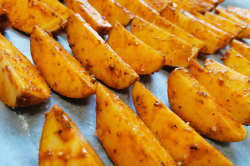 Baked potato wedges on parchment paper.