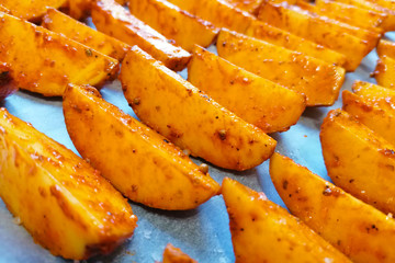 Baked potato wedges on parchment paper.