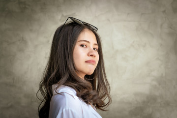 Beautiful Asian women with long hair wearing a white shirt. White bug hat, jeans showing emotions Cement wall 