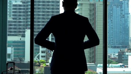 Young businessman admire view of the city from window at home, slow motion