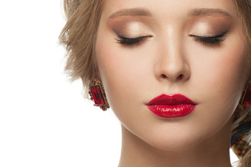 Beautiful female face close up portrait isolated. Eyes closed, beige eyeshadow makeup and red lips