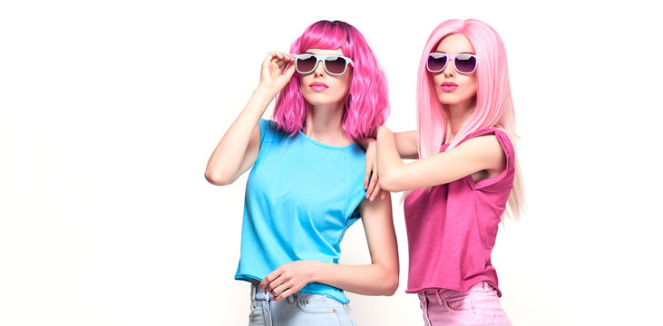 Fashion. Two beautiful hipster woman, stylish clothes, trendy pink hair. Cheerful shapely happy fashion girl, sisters friends on white. Creative fashionable trendy pink hairstyle swag cool concept