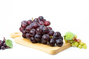 Purple grapes on a chopping block White background