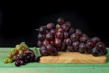 Purple grapes on a chopping block 