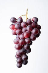 Purple grapes on a chopping block White background