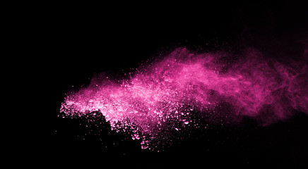 Pink powder explosion on black background. Colored cloud. Colorful dust explode. Paint Holi.