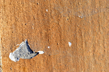 Yellow plastered walls of the house in cracks and damages