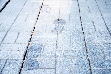 Wet footprints of a man on the pavement