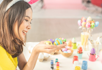 young beautiful girl paint color on easter egg