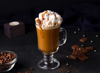 iced coffee with caramel and whipped cream on a black background