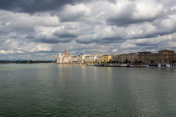 The hungarian Parliament in Budapest. Danube river. Cloudy sky.
