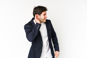 Young business man isolated on white background trying to listening a gossip.