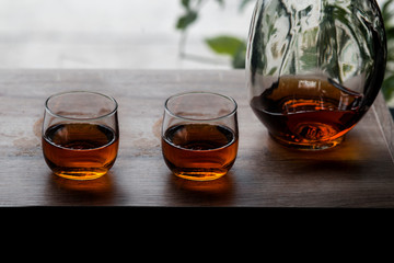 a glass of whiskey on wood bar, soft focus.	