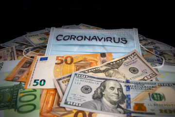 Coronavirus inscription on a medical mask on top of world international banknotes. US dollars and euros. Coronavirus Warning.