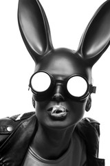 Obraz premium masked easter bunny blowing bubble gum bubbles. Easter party concept