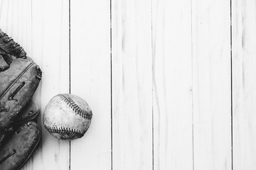 Baseball ball and glove on wood background.