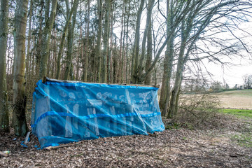 Mit Planen bedeckter Unterstand für frisches Brennholz