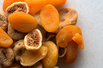 Dried figs and apricots on white background 