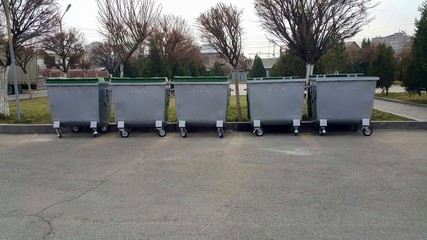 Five gray trash bins installed in the city for various types of materials