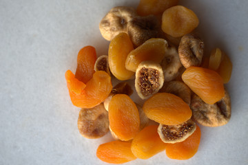 Dried figs and apricots on white background 