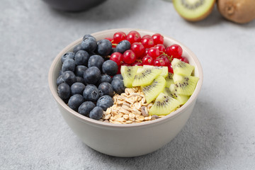 Healthy delicious Breakfast. Muesli with blueberries, red currants, kiwi and yogurt.