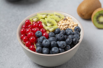 Healthy delicious Breakfast. Muesli with blueberries, red currants, kiwi and yogurt.