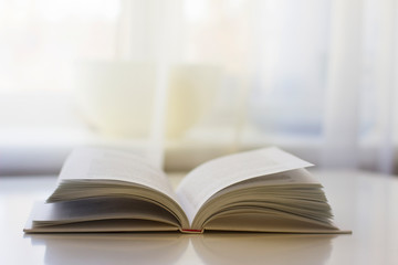 An open book lies on a white table. Education concept.