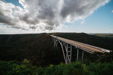Fototapeta na wymiar High bridge over a green valley in Cuba