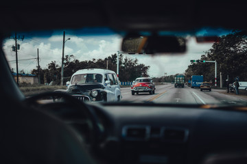 Havana, Cuba; Sep 26 2017: Retro classic American cars drive, viewed from inside car