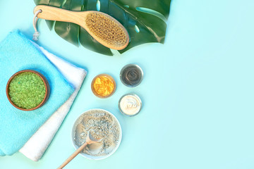 spa massage clay powder, face masks, bath salt, towel, shea butter on blue table background.
