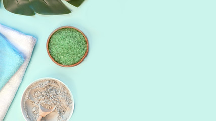 spa massage clay powder, face masks, bath salt, towel, shea butter on blue table background.