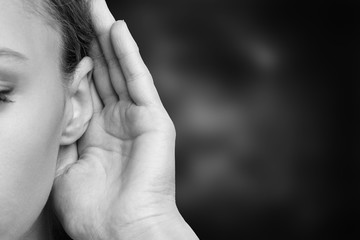 Fototapeta premium A woman holds hand near her ear and listening to something